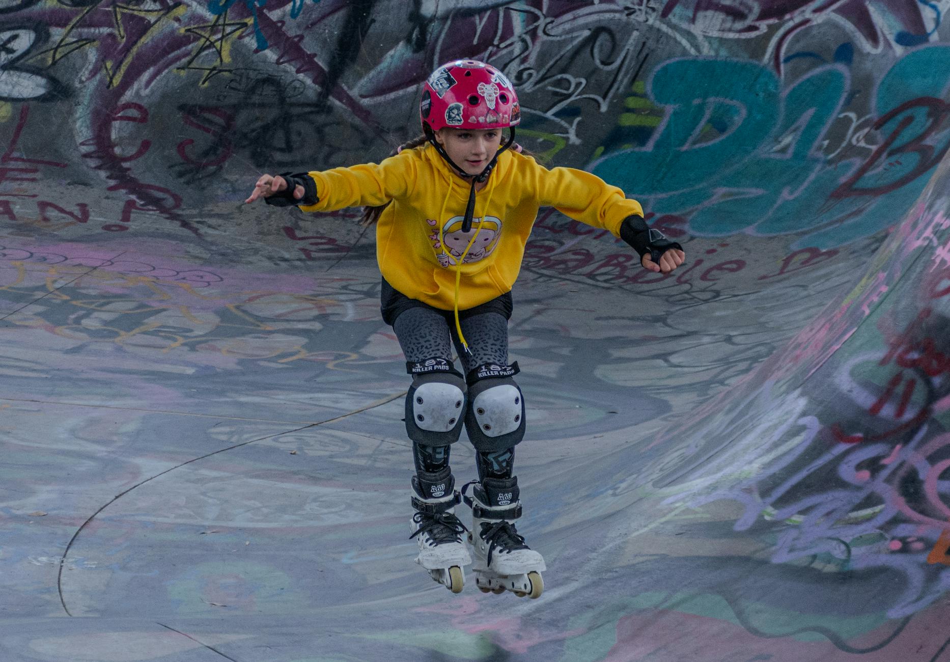 Dziecko na rolkach w kolorowym skateparku z graffiti