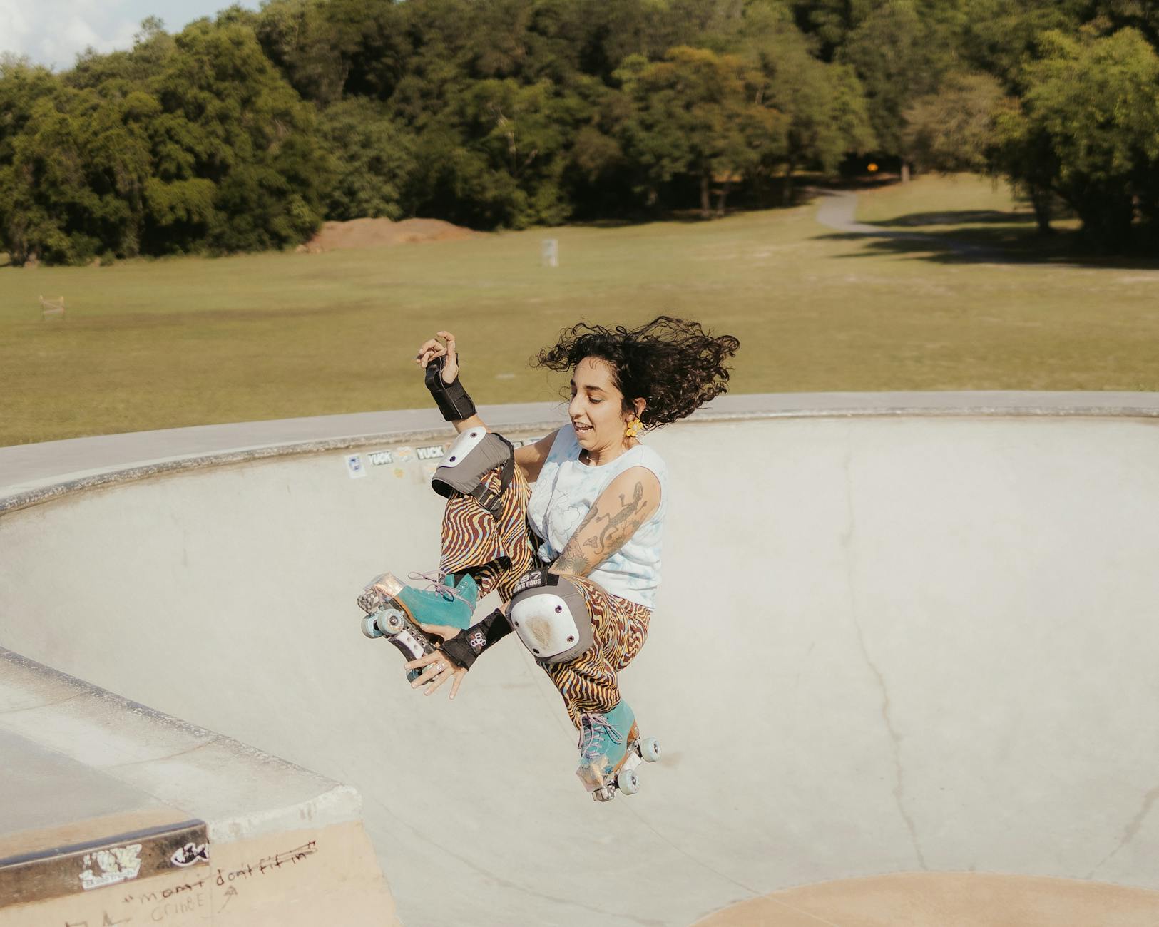 Kobieta energicznie jeżdżąca na rolkach w niecce skateparku